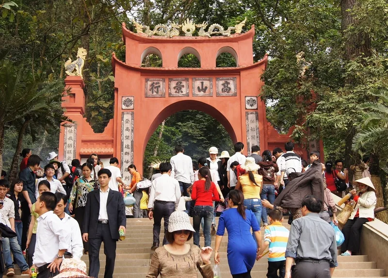 Đông đảo du khách bước lên cầu thang qua cổng đỏ tại khu di tích Đền Hùng, Phú Thọ.