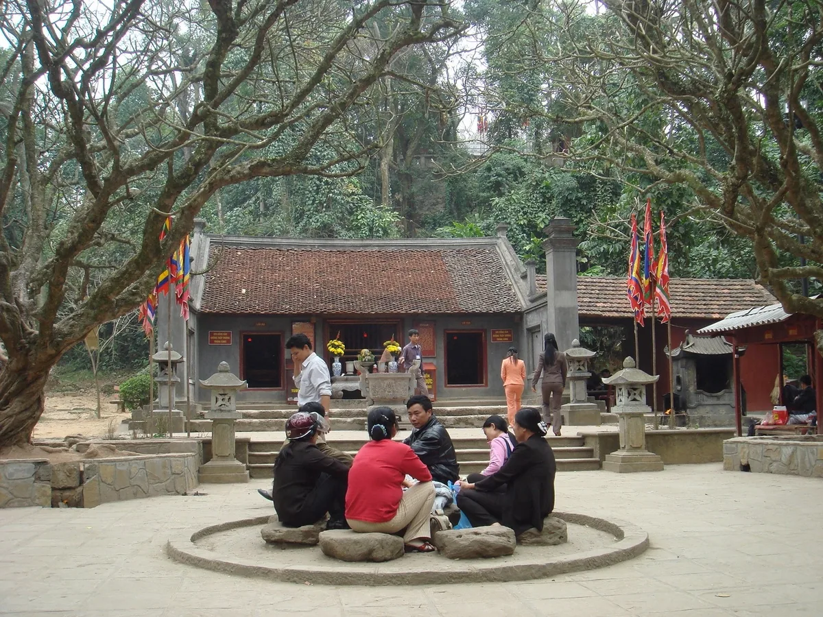 Du khách ngồi quây quần dưới gốc cây trong khuôn viên đền, khu di tích Đền Hùng, Phú Thọ, phía sau là ngôi đền mái đỏ. Du khách ngồi quây quần dưới gốc cây trong khuôn viên đền, khu di tích Đền Hùng, Phú Thọ, phía sau là ngôi đền mái đỏ.