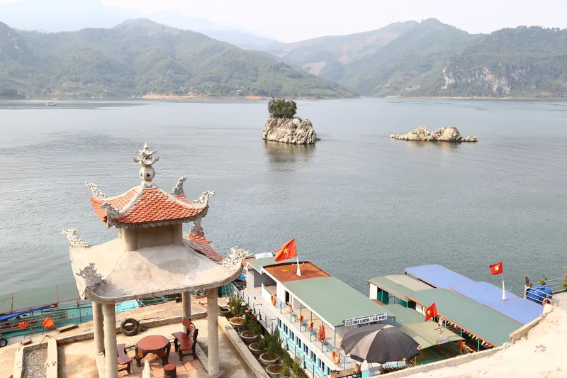 Một chòi nghỉ kiểu chùa nhìn ra hồ Sông Đà với các đảo đá nhỏ và núi ở Thung Nai, Hòa Bình. Một chòi nghỉ kiểu chùa nhìn ra hồ Sông Đà với các đảo đá nhỏ và núi ở Thung Nai, Hòa Bình.